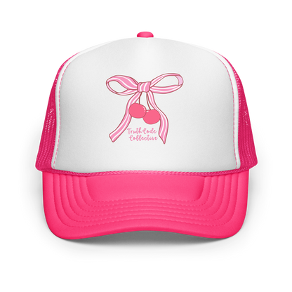 Pink and white trucker hat with a bow and cherry design on a white background