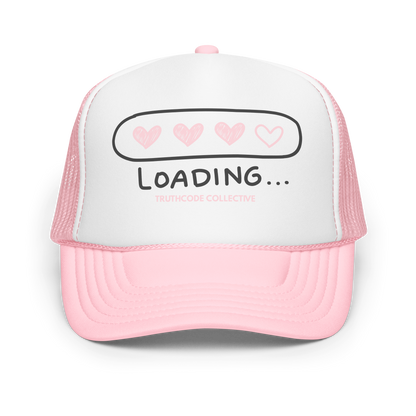 Pink and white trucker hat with 'LOADING...' text and heart symbols on a white background