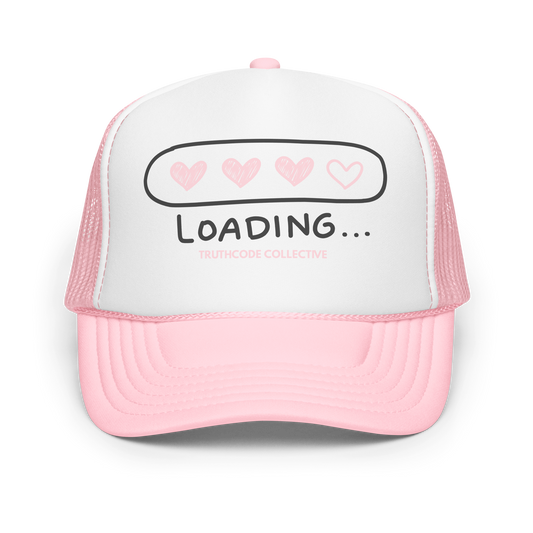 Pink and white trucker hat with 'LOADING...' text and heart symbols on a white background