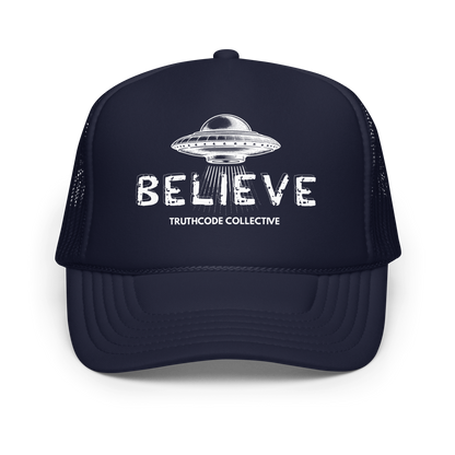 Navy blue trucker hate with UFO design and 'BELIEVE' text on a white background