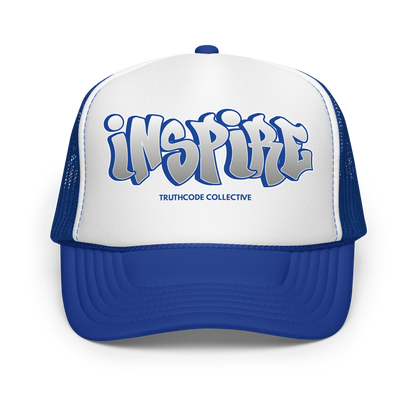 Blue and white cap with graffiti style text 'inspire', on a white background