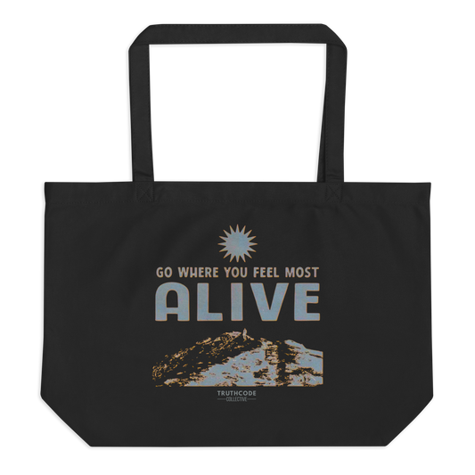 Black organic tote bag with motivational quote 'Go where you feel most alive' and sun graphic on a white background