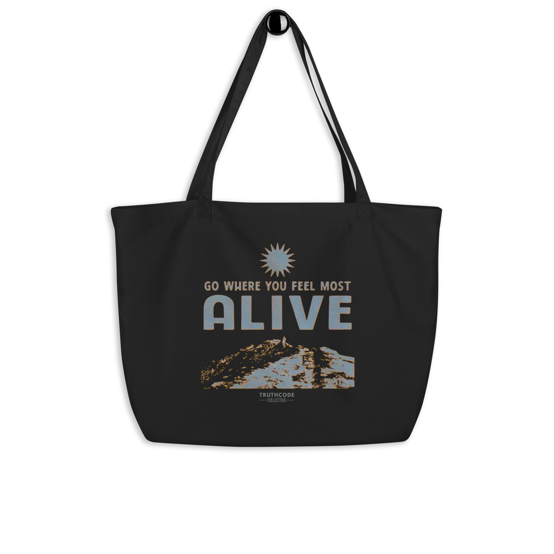 Black organic tote bag with motivational quote 'Go where you feel most alive' and nature graphic on a white background