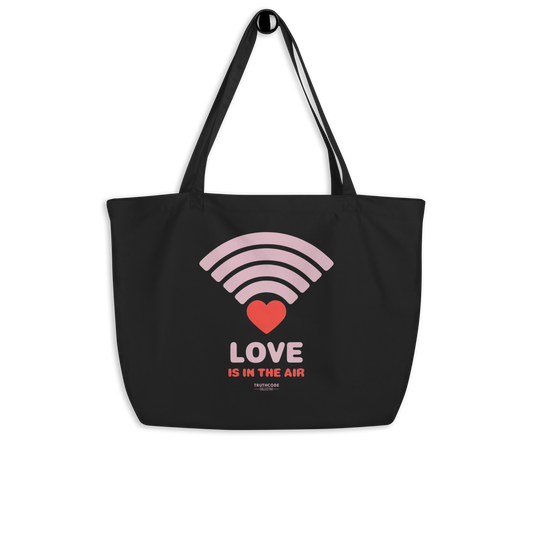 Black organic tote bag with pink heart wifi graphic design and text 'LOVE IS IN THE AIR' on a white background
