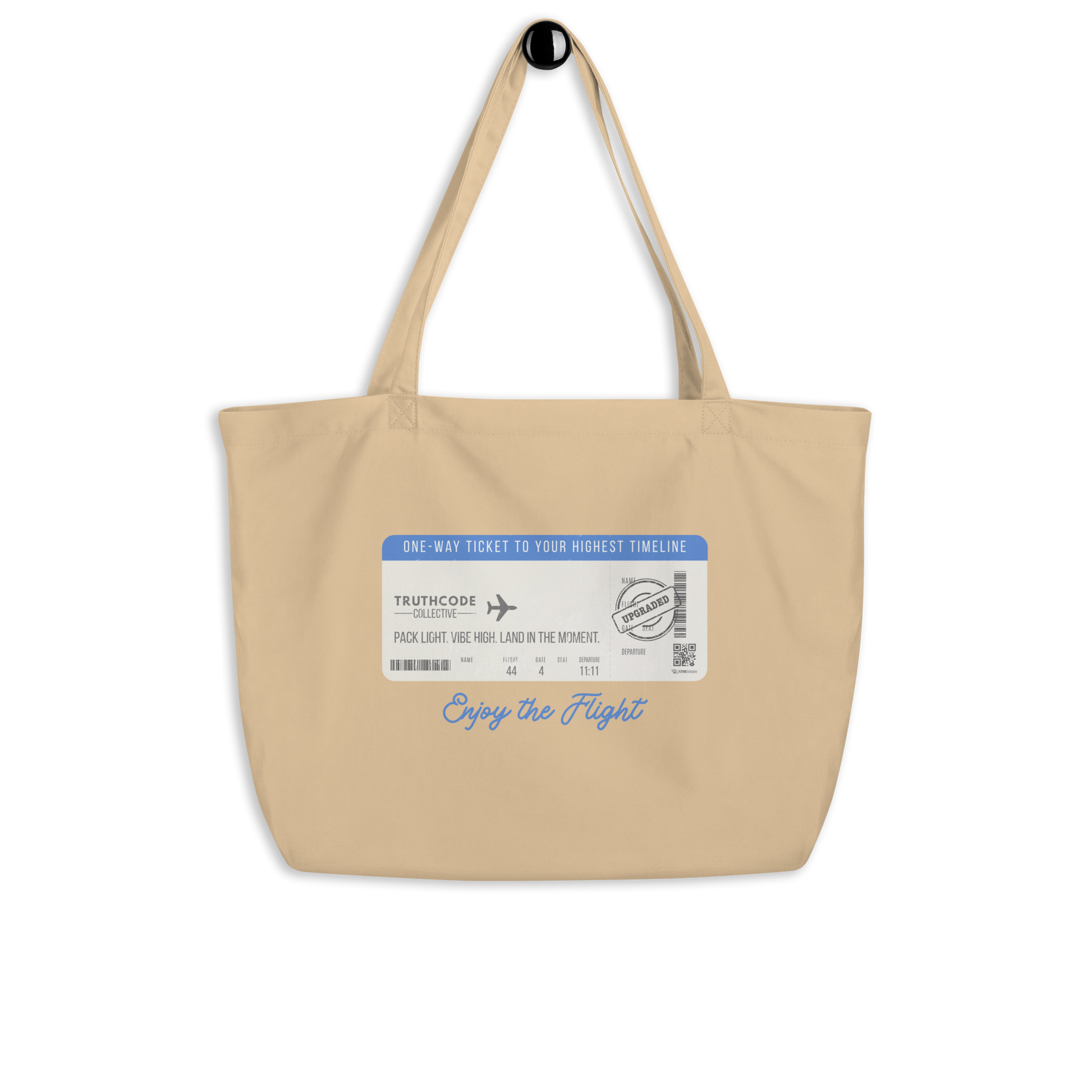 Beige organic tote bag with airline ticket graphic and text reading 'Enjoy the flight' on a white background