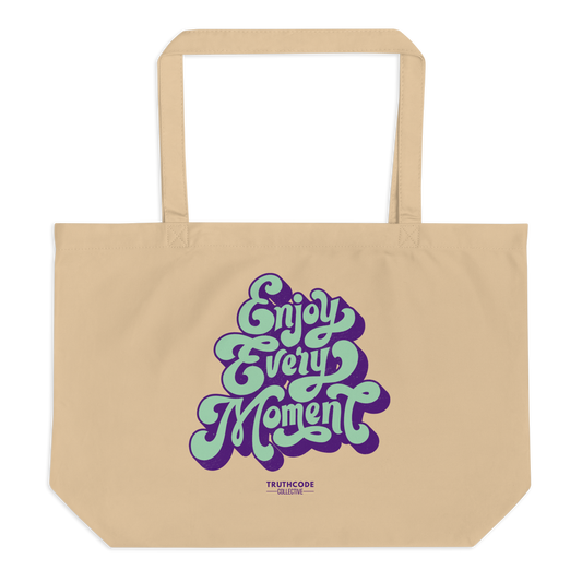 Beige organic tote bag with 'Enjoy Every Moment' text in purple and green on a white background