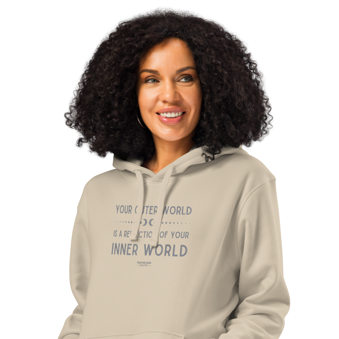 Woman wearing beige organic hoodie with text 'Your outer world is a reflection of your inner world' on a white background