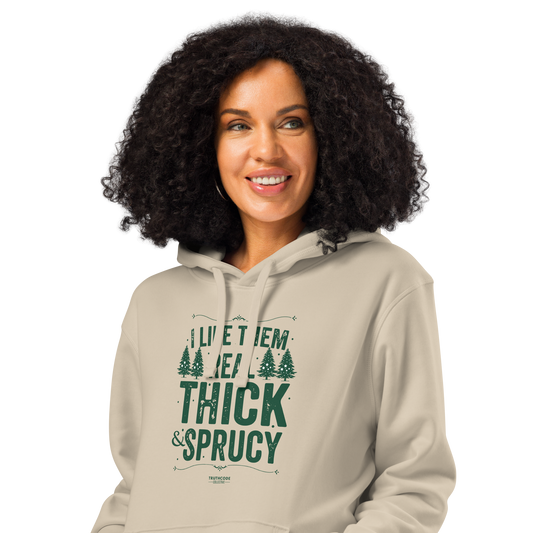 Woman wearing beige organic hoodie with text 'I like them real thick and sprucy' and tree graphic designs on a white background