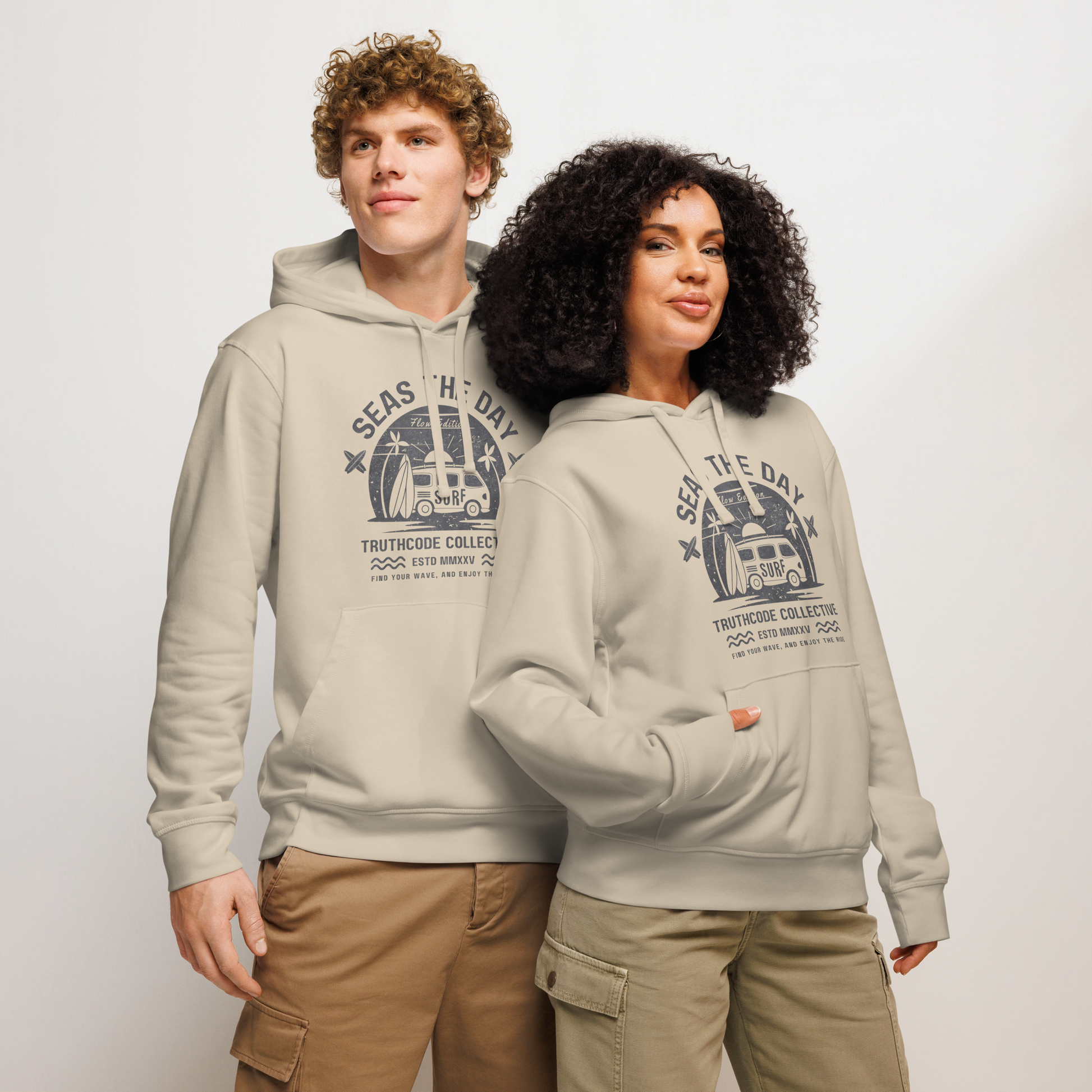 Models wearing beige organic hoodie with graphic design of a vintage surfing van and text 'SEAS THE DAY' on a white background