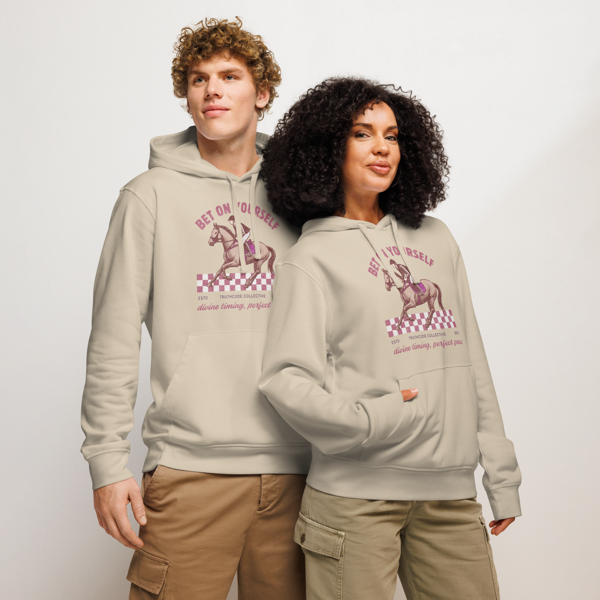 Models wearing beige organic hoodie with graphic design of race horse and jockey and text 'Bet on yourself' on a plain background