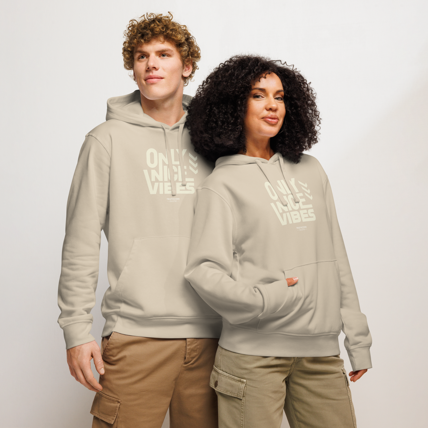 Models wearing beige organic hoodie with 'Only Nice Vibes' text design on a white background