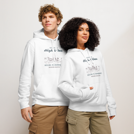 Models wearing white organic hoodie with fishing boat graphic design and text 'Hooked on high vibes, reeling in abundance',  on a white background