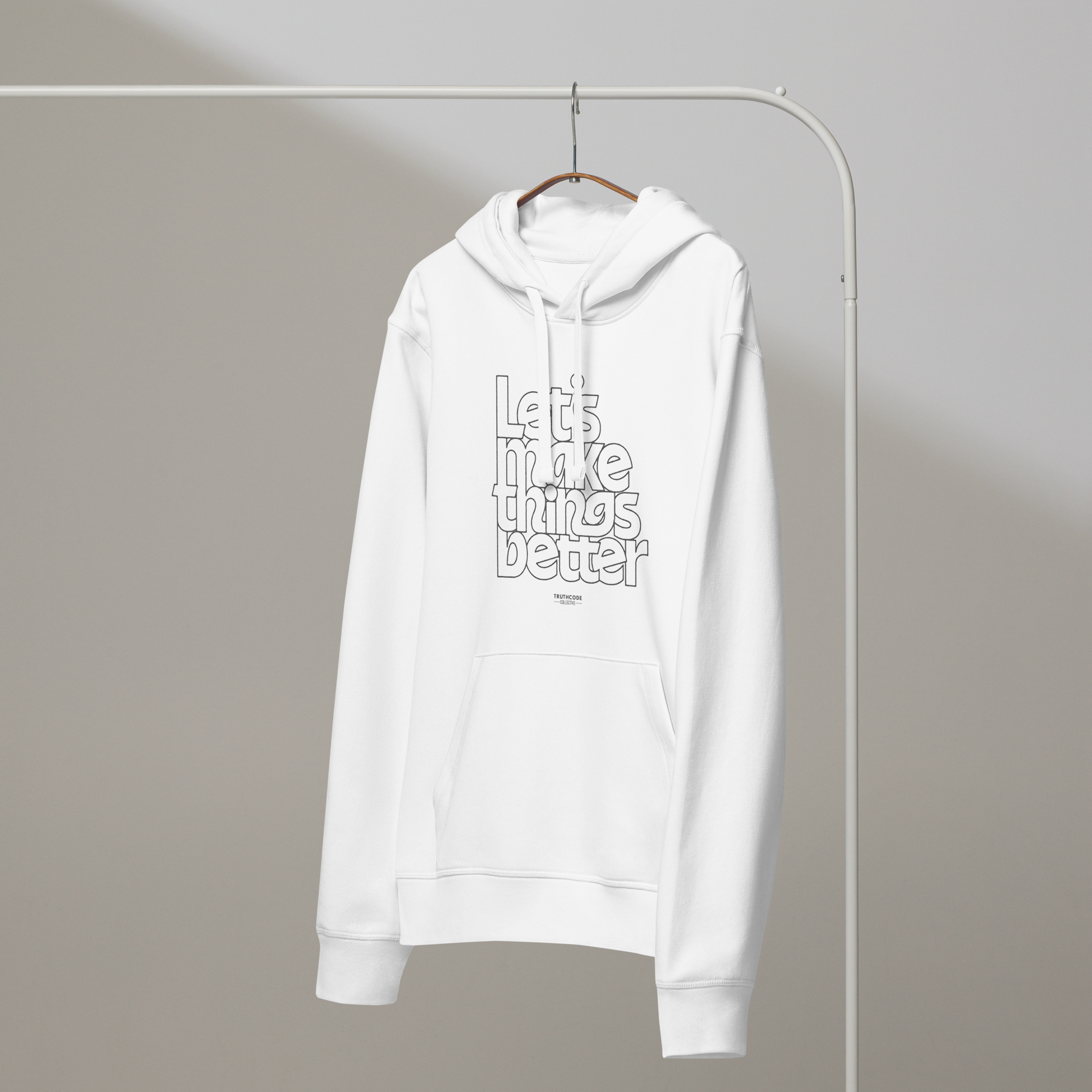 White organic hoodie with 'Let's Make Things Better' text on a hanger against a gray wall background