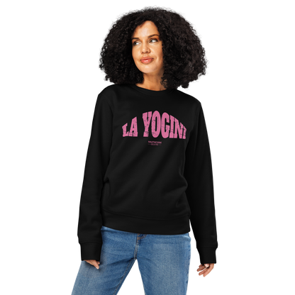 Woman wearing black organic sweatshirt with pink 'LA YOGINI' text on a white background