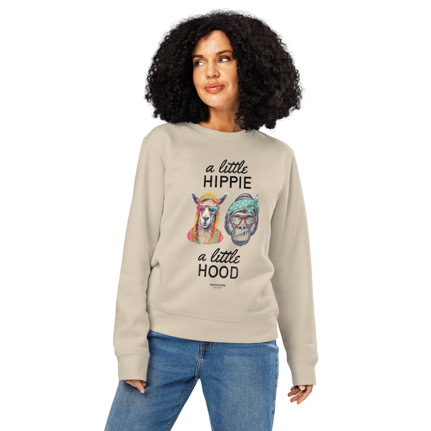 Woman wearing beige organic sweatshirt with a graphic of a llama and monkey wearing headbands and text ' A little hippie, a little hood' on a white background