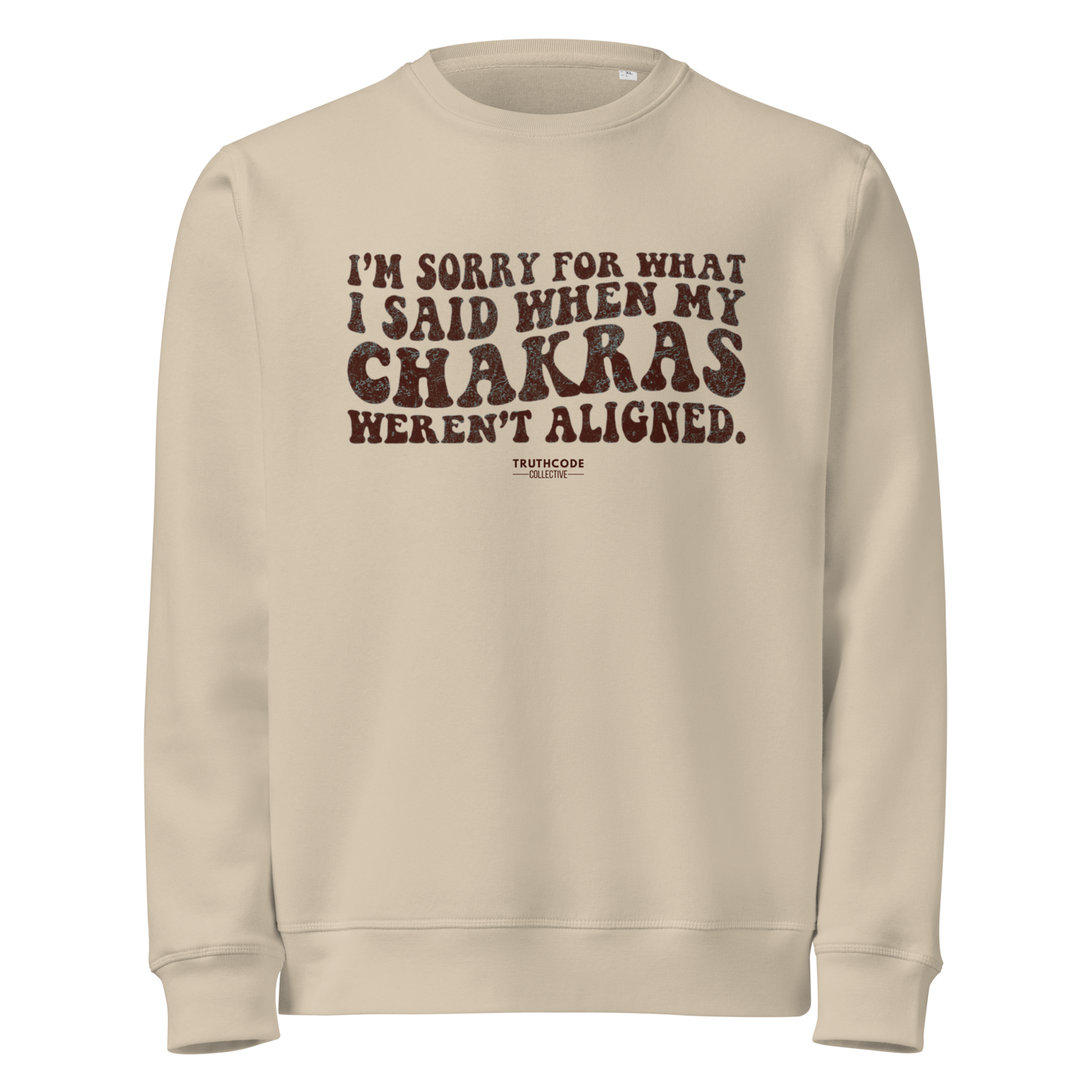 Beige organic sweatshirt with humorous text 'I'm sorry for what i said when my chakras weren't aligned' on a white background