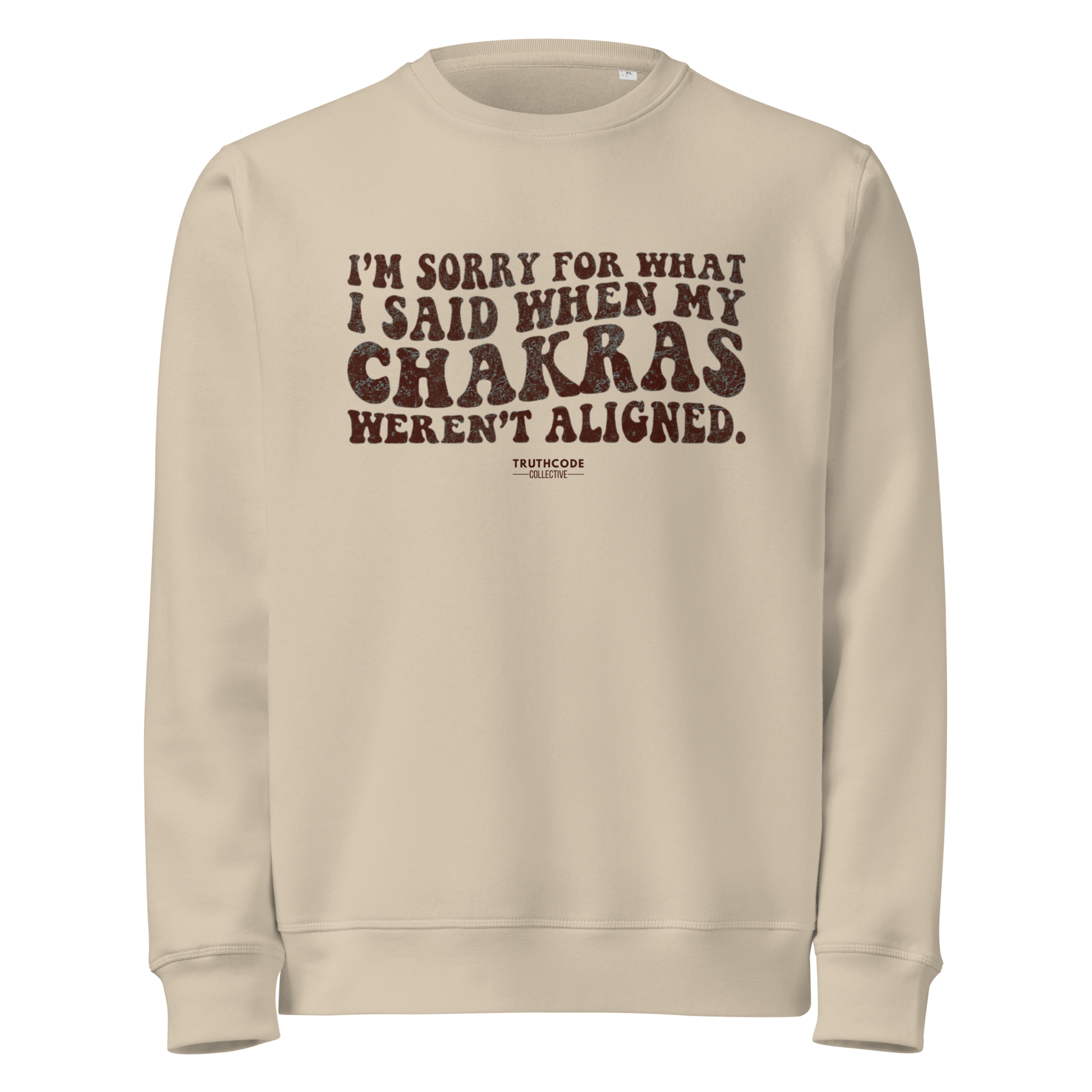Beige organic sweatshirt with humorous text 'I'm sorry for what i said when my chakras weren't aligned' on a white background