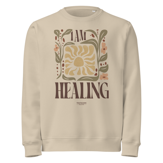 Beige organic sweatshirt with 'I AM HEALING' text and sun and plants design on a white background
