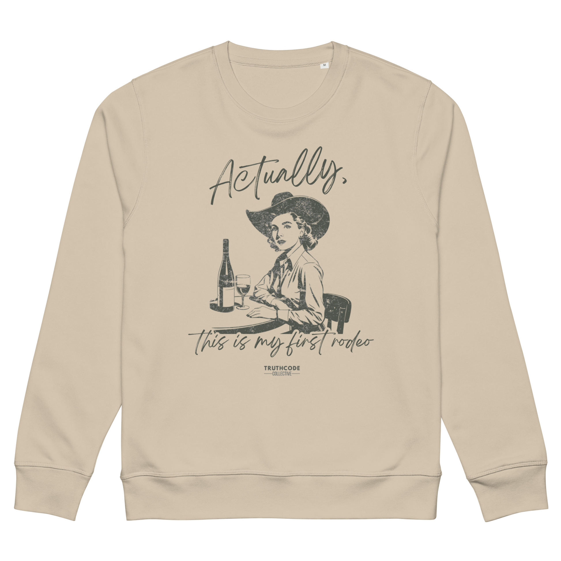 Beige organic sweatshirt with a vintage style graphic of a woman in a cowboy hat and text 'Actually, this is my first rodeo' on a white background