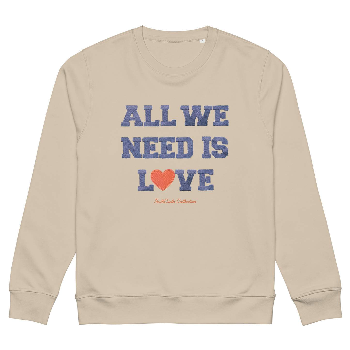 Beige organic sweatshirt with 'All We Need Is Love' text and heart graphic on a white background