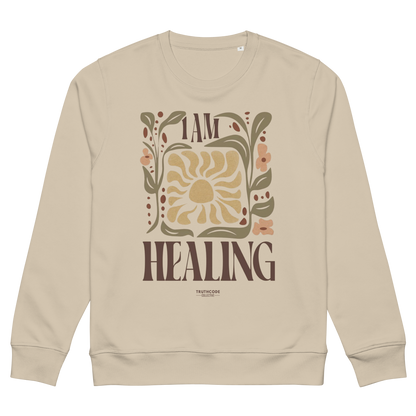 Beige organic sweatshirt with 'I AM HEALING' text and floral design on a white background