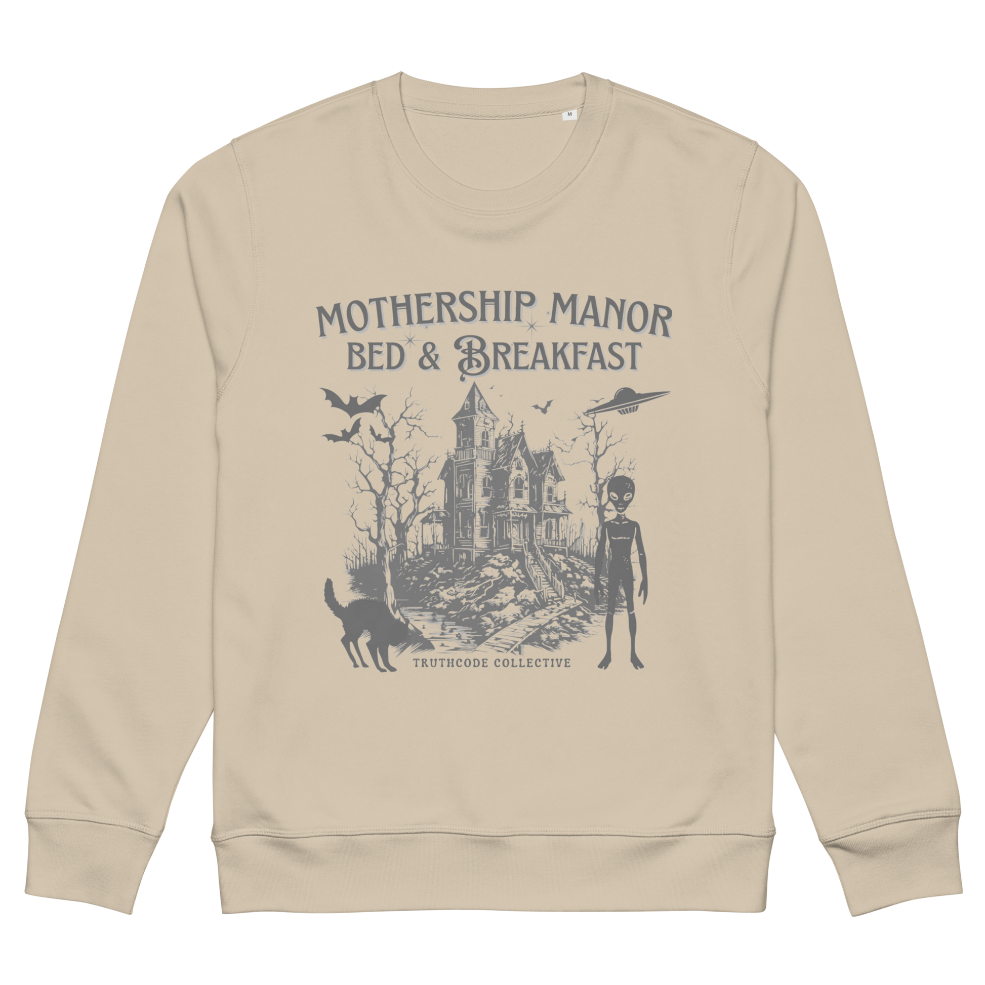 Beige organic sweatshirt with a graphic design of a haunted house, alien, and spaceship, with text 'Mothership Manor Bed & Breakfast' on a white background
