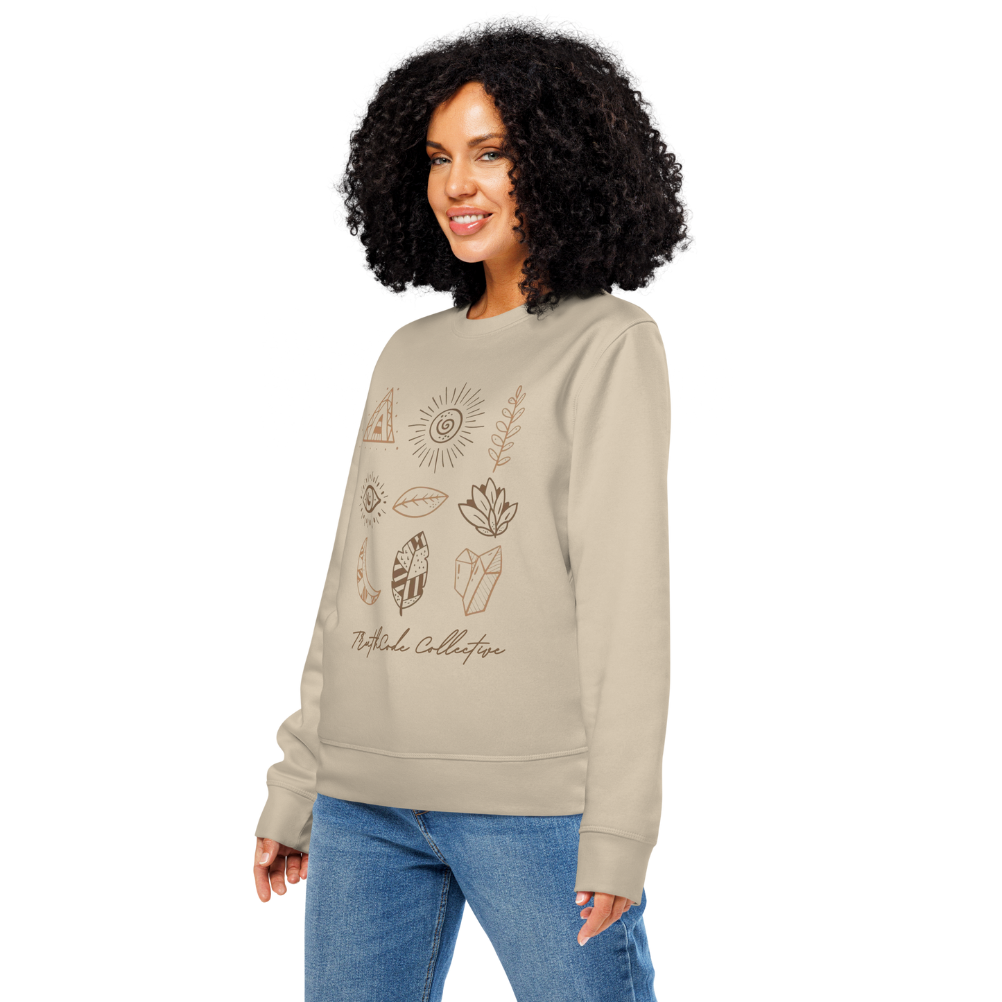 Woman wearing beige organic sweatshirt with graphic designs of mystic markings- symbols of feathers, crystals,  earthy motifs, etc., on a white background