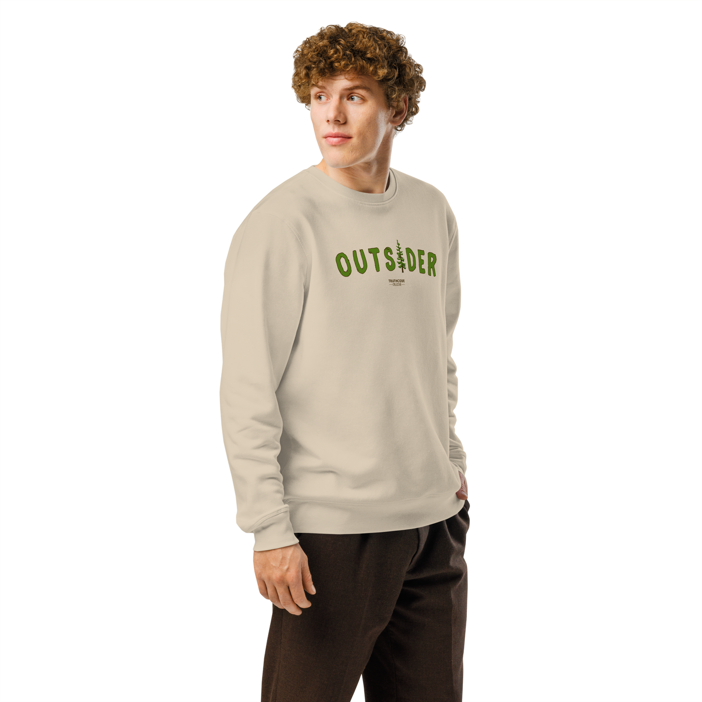 Guy wearing beige organic sweatshirt with 'OUTSIDER' text and evergreen tree graphic on a white background