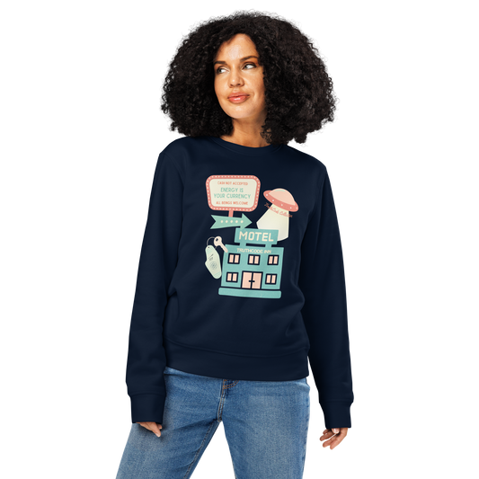 Woman wearing navy blue organic sweatshirt with a colorful graphic of a motel sign and spaceship with text 'Cash not accepted, Energy is your currency, all beings welcome' on a white background