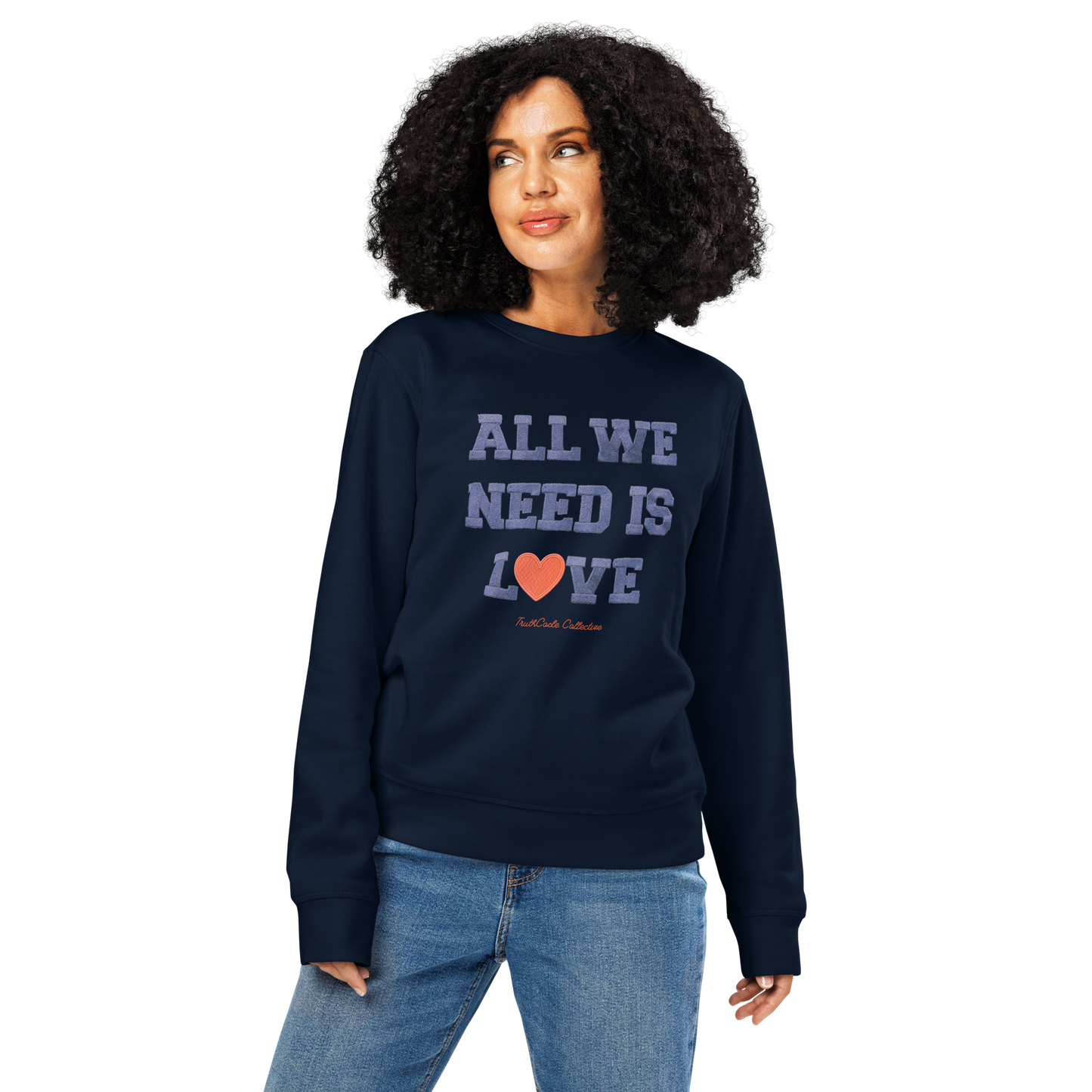 Woman wearing navy blue organic sweatshirt with 'All We Need Is Love' text on a white background
