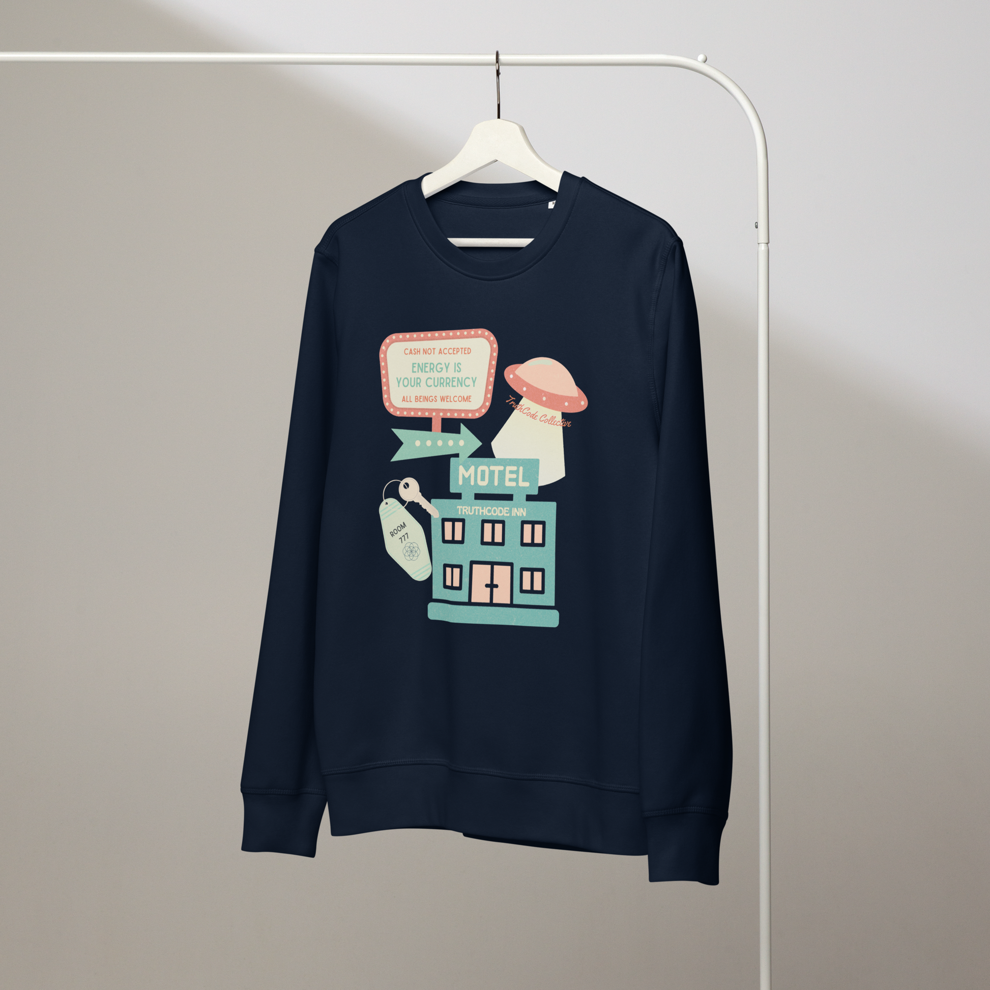 Navy blue organic sweatshirt with a colorful graphic of a motel sign and spaceship with text 'Cash not accepted, Energy is your currency, all beings welcome' on a white hanger with a gray wall background