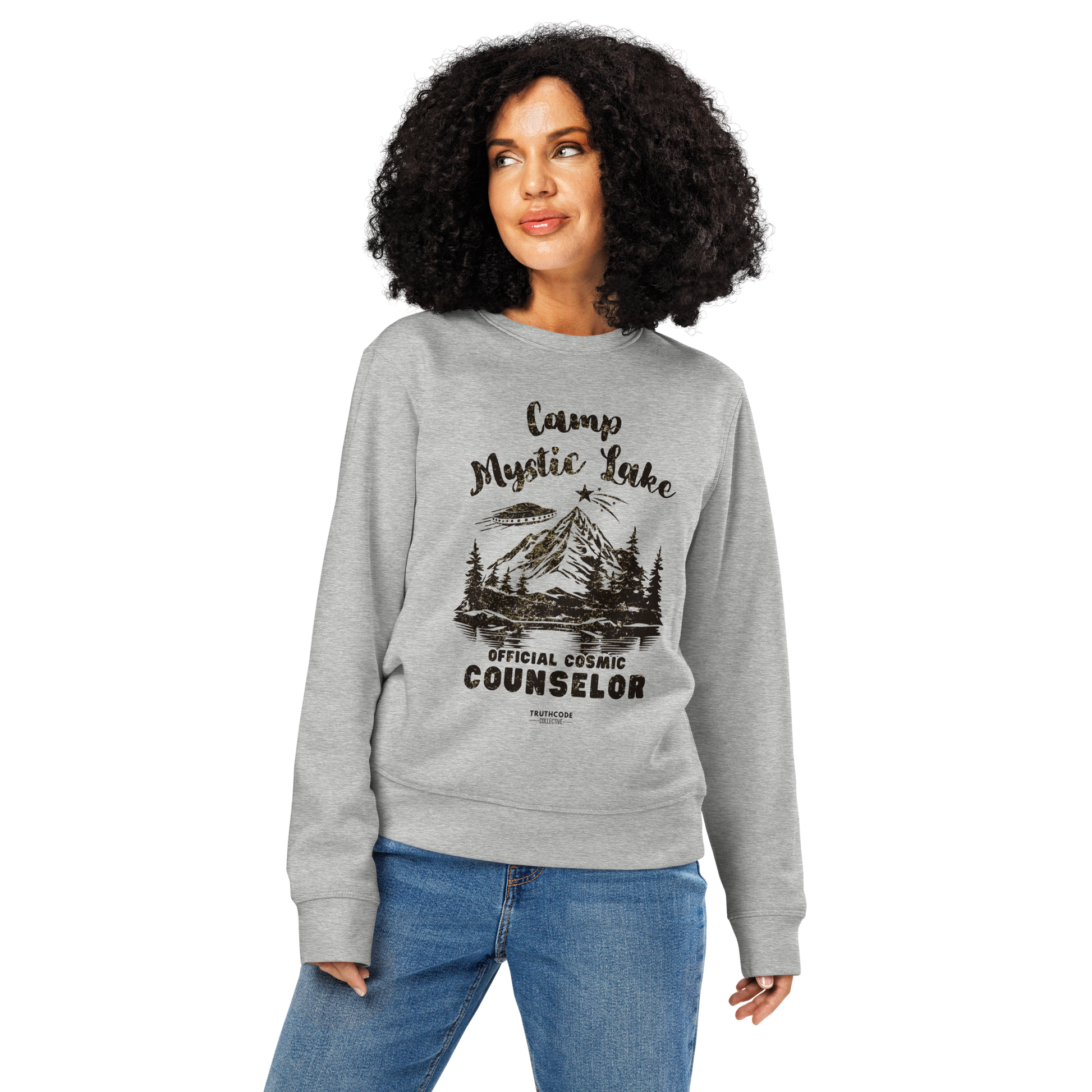 Woman wearing gray organic sweatshirt with mountain scene and spaceship graphic design and text 'Camp Mystic Lake, official cosmic counselor' on a white background