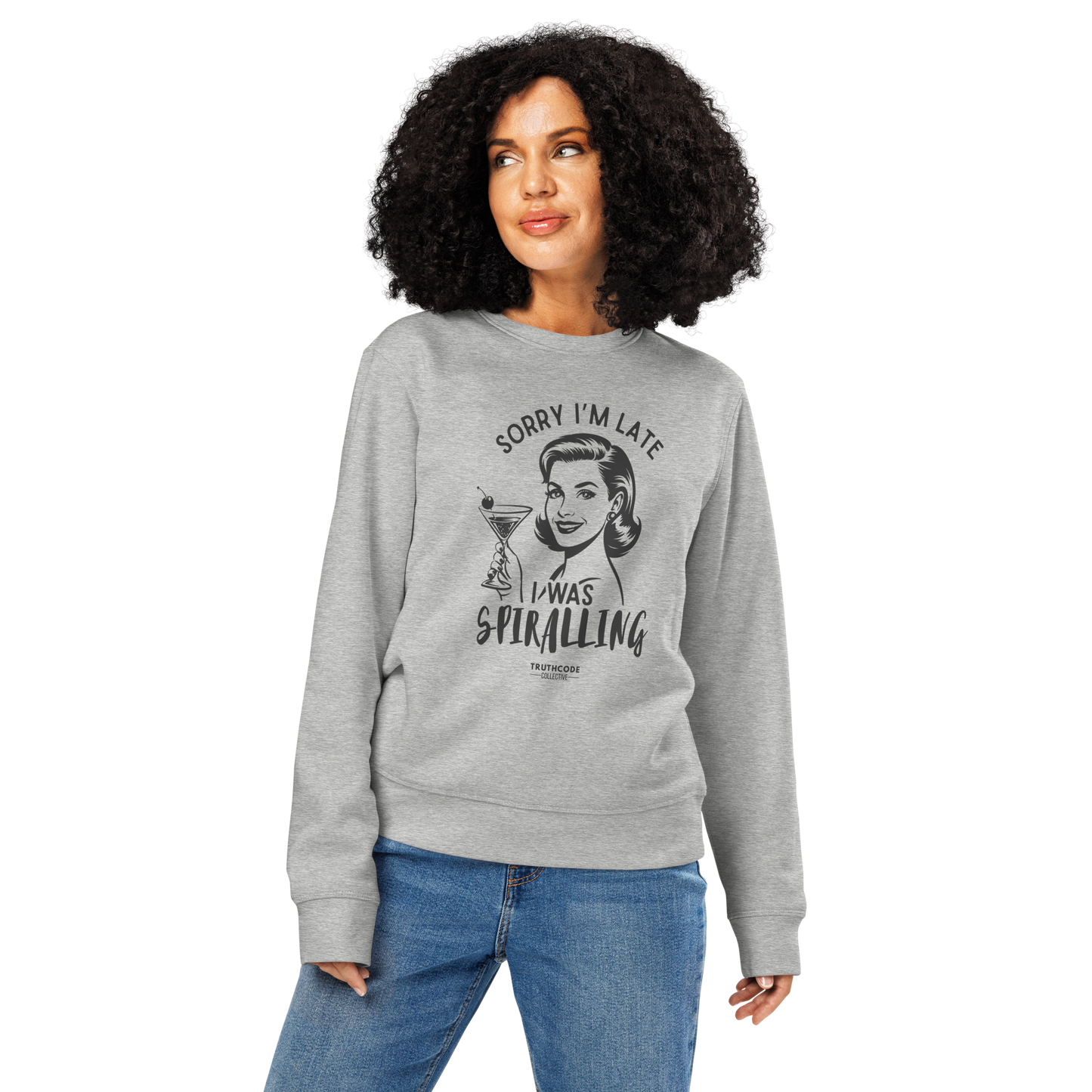 Woman wearing gray organic sweatshirt with vintage graphic design of woman holding a drink and text 'Sorry I'm late I was spiraling' on a white background
