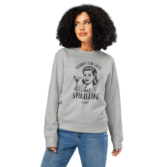 Woman wearing gray organic sweatshirt with vintage graphic design of woman holding a drink and text 'Sorry I'm late I was spiraling' on a white background