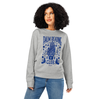 Woman wearing gray organic sweatshirt with blue 'Palm Reading Club' and graphic design of a hand with different elements of palm reading, on a white background