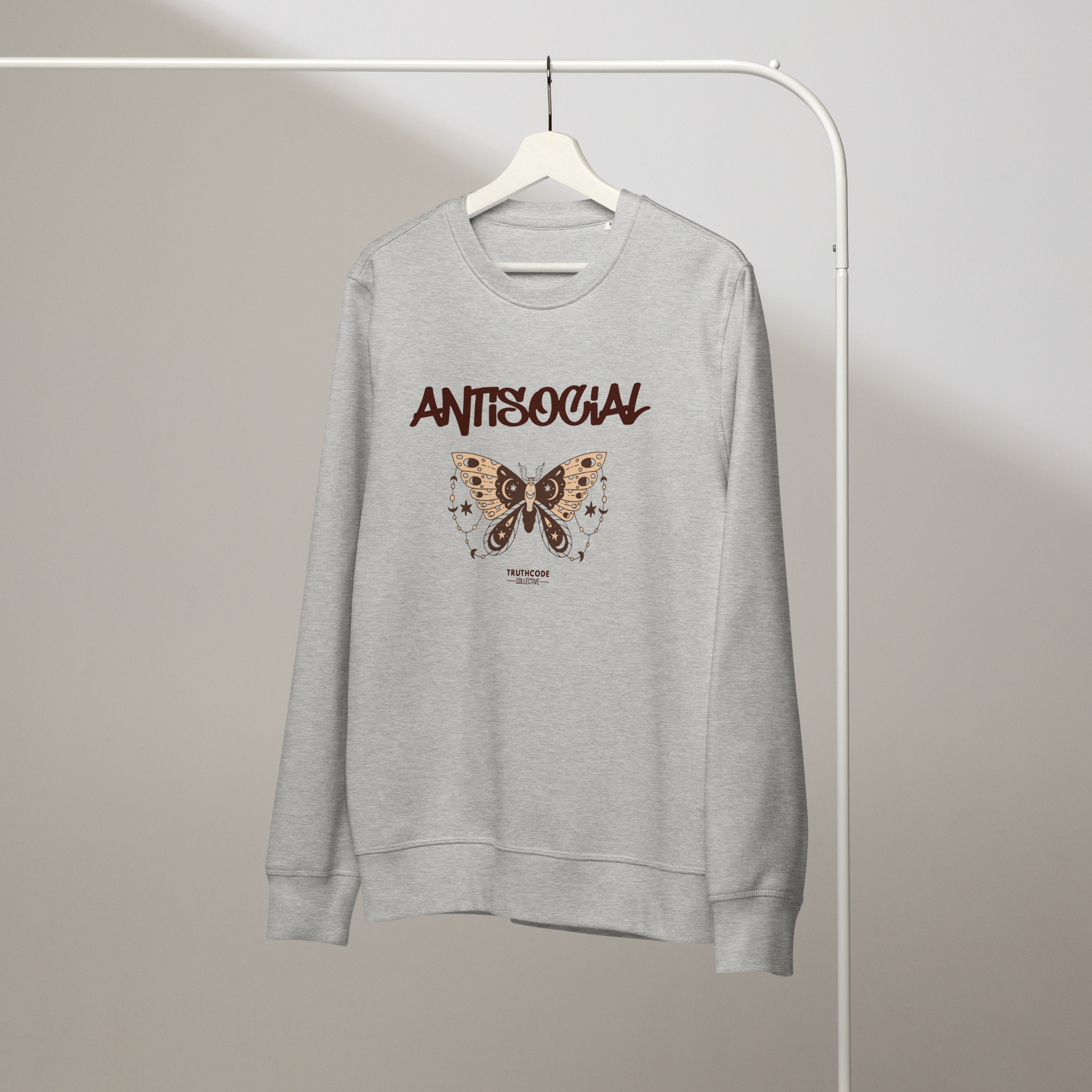 Gray organic sweatshirt with butterfly graphic and 'ANTISOCIAL' text on a hanger with a gray wall background