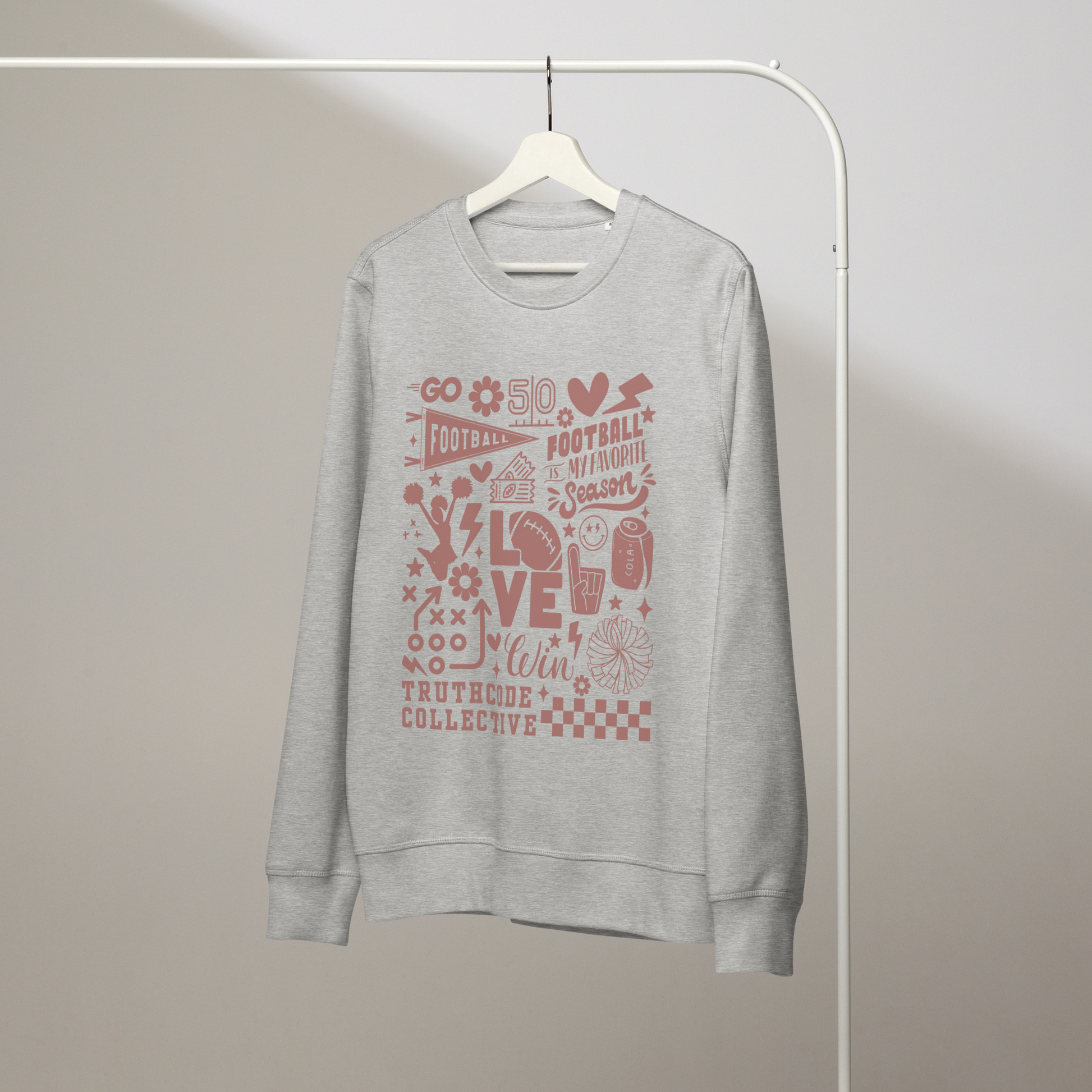 Gray organic sweatshirt with football themed graphics and text 'Football is my favorite season' on a white hanger with a gray wall background