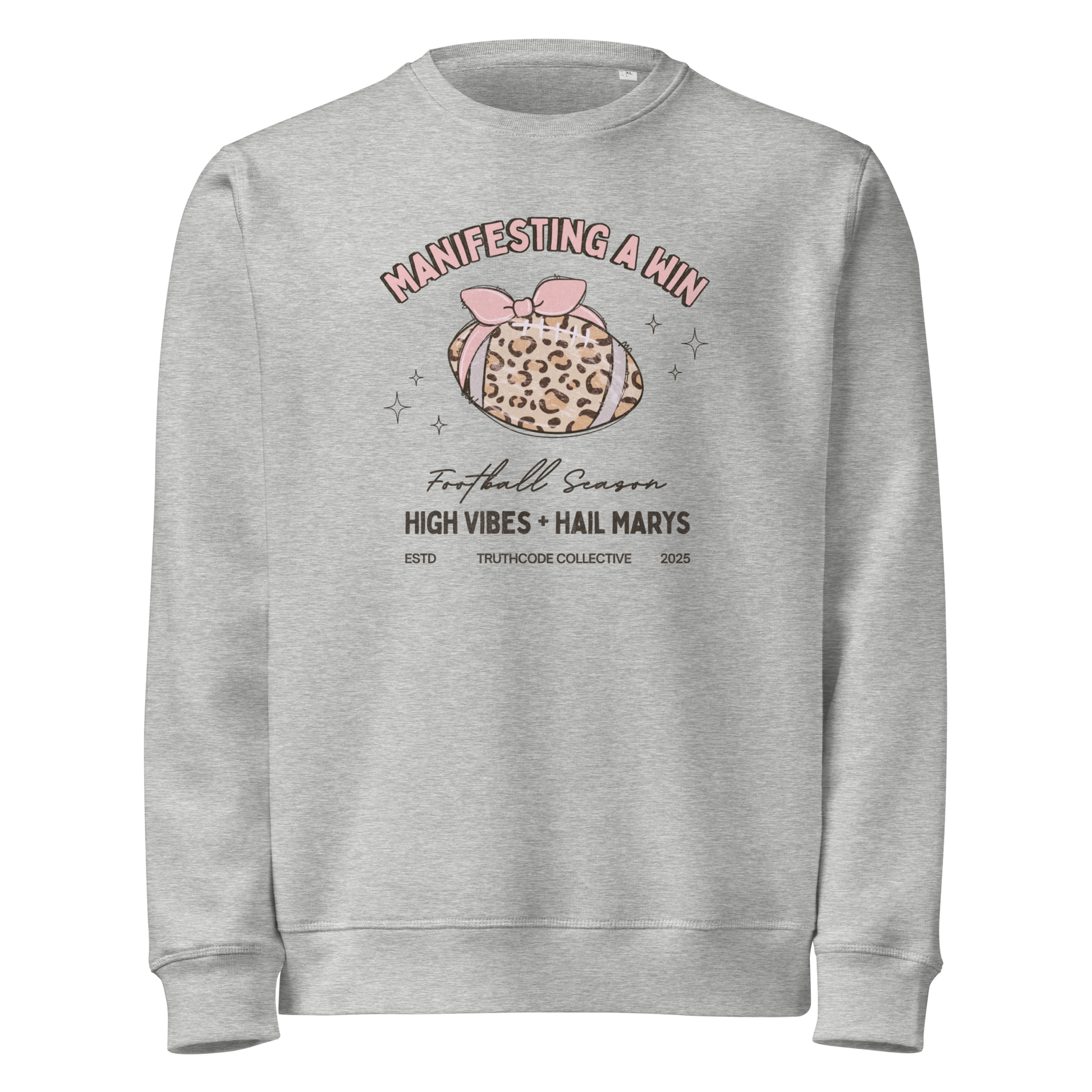 Gray organic sweatshirt with girly football graphic design and text 'Manifesting a win, high vibes + hail marys' on a white background