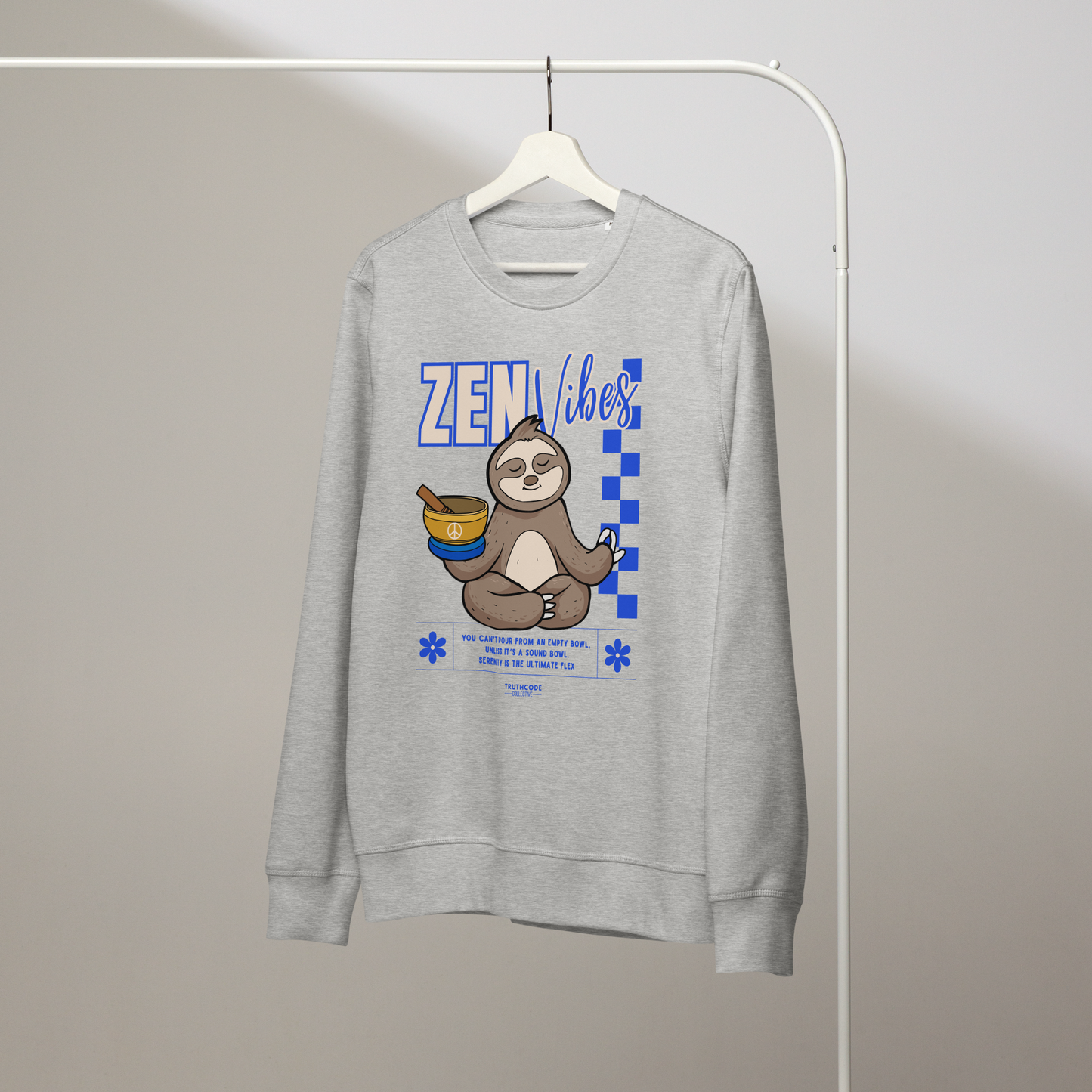 Gray organic sweatshirt with a sloth graphic and 'Zen Vibes' text on a white hanger with a gray wall background