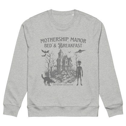 Gray organic sweatshirt with a graphic design of a haunted house, alien, and spaceship, with text 'Mothership Manor Bed & Breakfast' on a white background