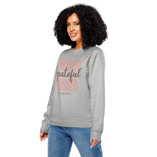 Woman wearing gray organic sweatshirt with 'Thankful grateful BLESSED' text design on a white background