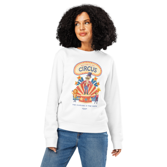 Woman wearing white organic sweatshirt with circus-themed graphic design and text 'Welcome to the circus' and 'The illusion is the show' on a white background