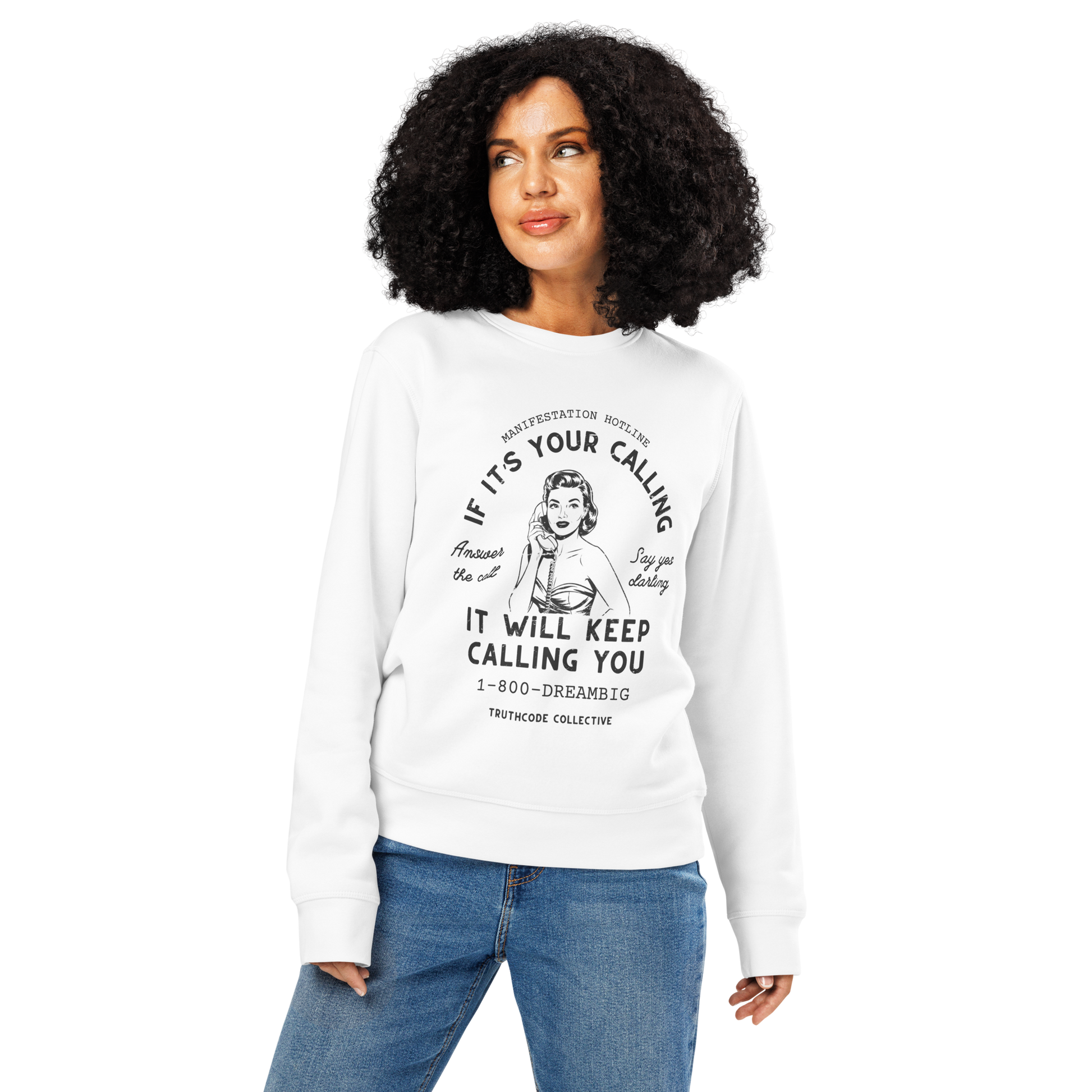 Woman wearing white organic sweatshirt with vintage-style graphic of a woman on the phone and text 'If it's your calling, it will keep calling you' and '1-800-DREAMBIG' on a white background
