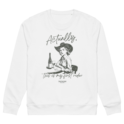 White organic sweatshirt with a vintage style graphic of a woman in a cowboy hat and text 'Actually, this is my first rodeo' on a white background
