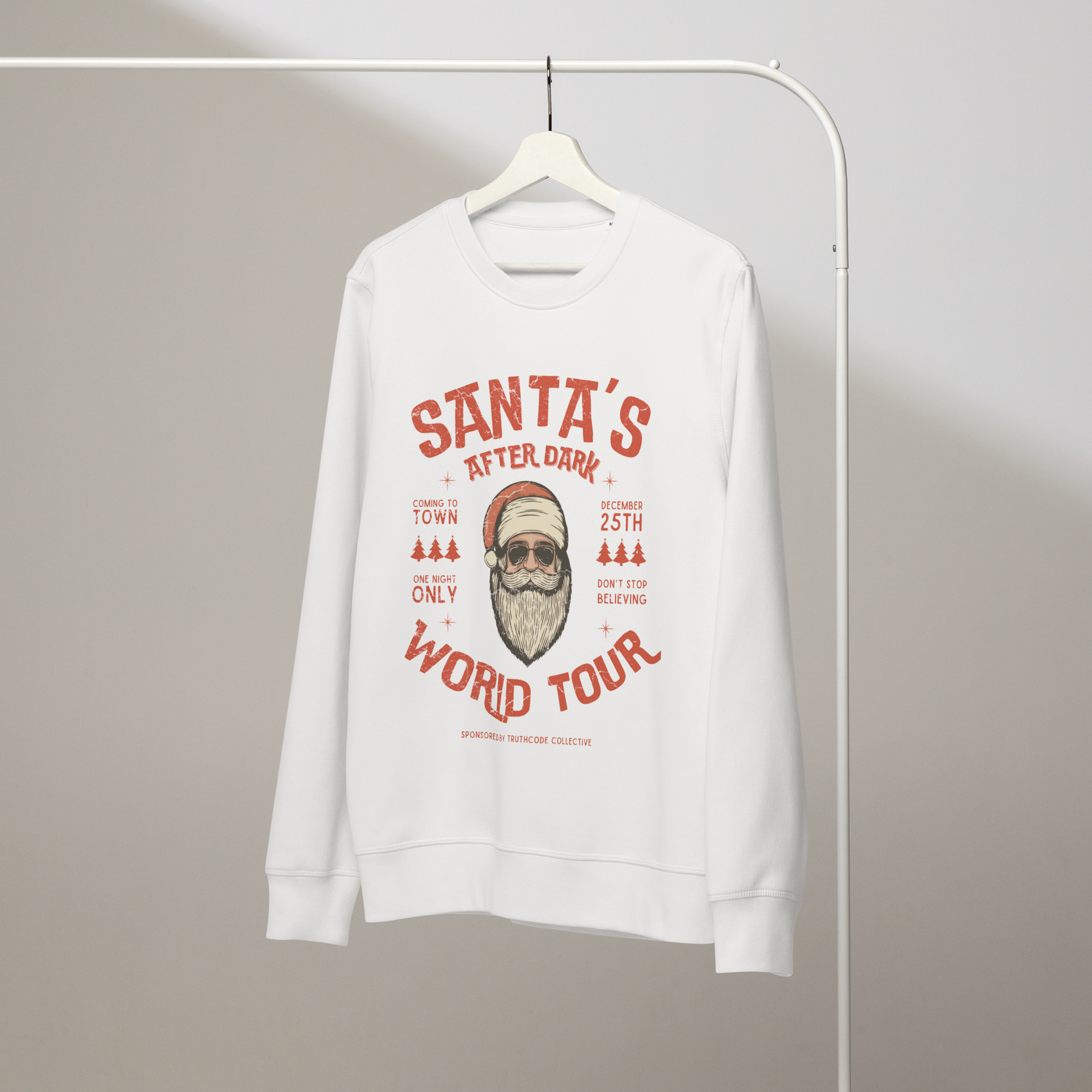 White organic sweatshirt with Santa Claus in sunglasses graphic and text 'Santa's after dark world tour' on a hanger with a gray wall background