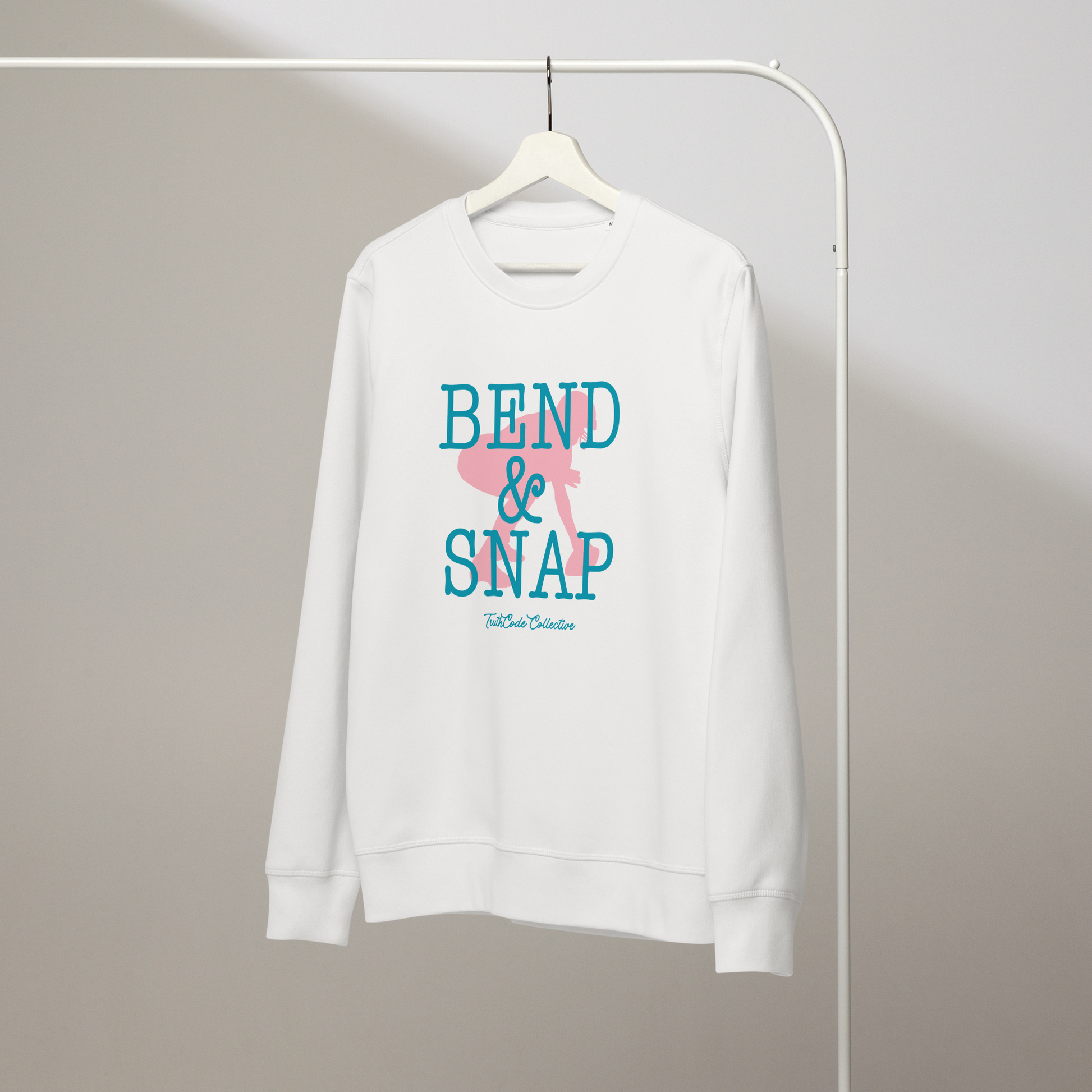 White organic sweatshirt with 'Bend & Snap' text and graphic design of football center ready to snap the ball, on a hanger with a gray wall background