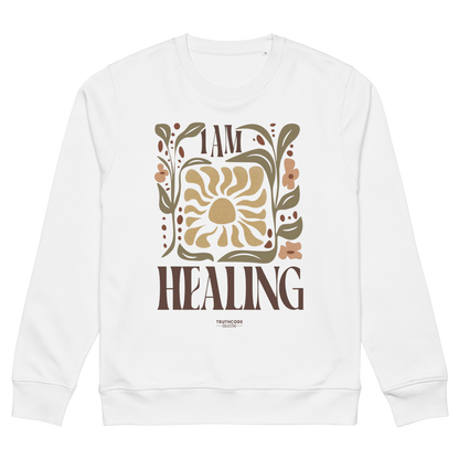 White organic sweatshirt with 'I AM HEALING' text and floral design on a white background