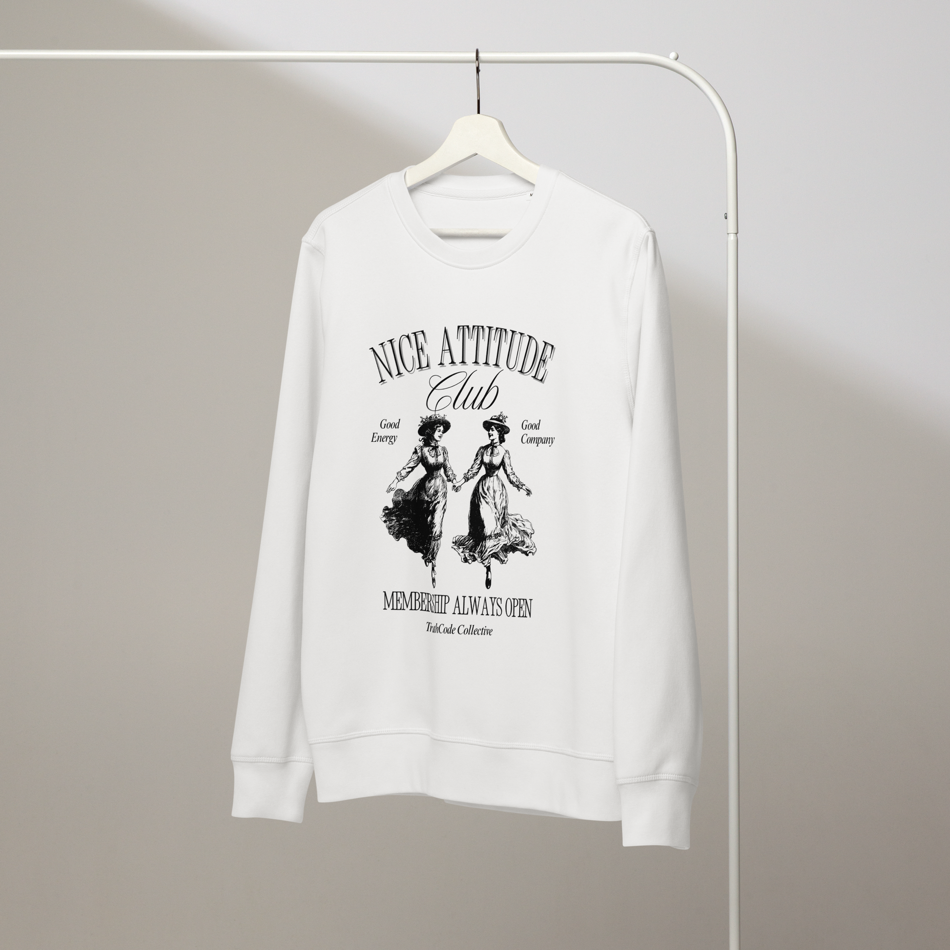 White organic sweatshirt with black vintage style graphic design and text 'Nice attitude club, membership always open' on a hanger with a gray wall background