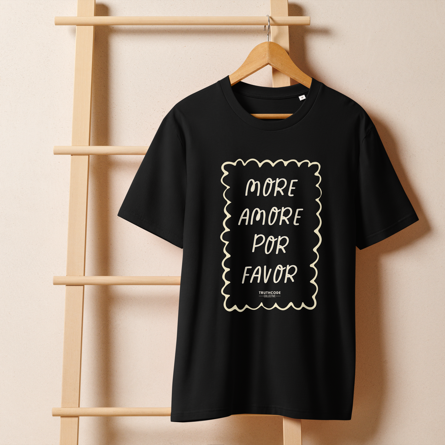 Black organic t-shirt with white text 'MORE AMORE POR FAVOR' on a white background