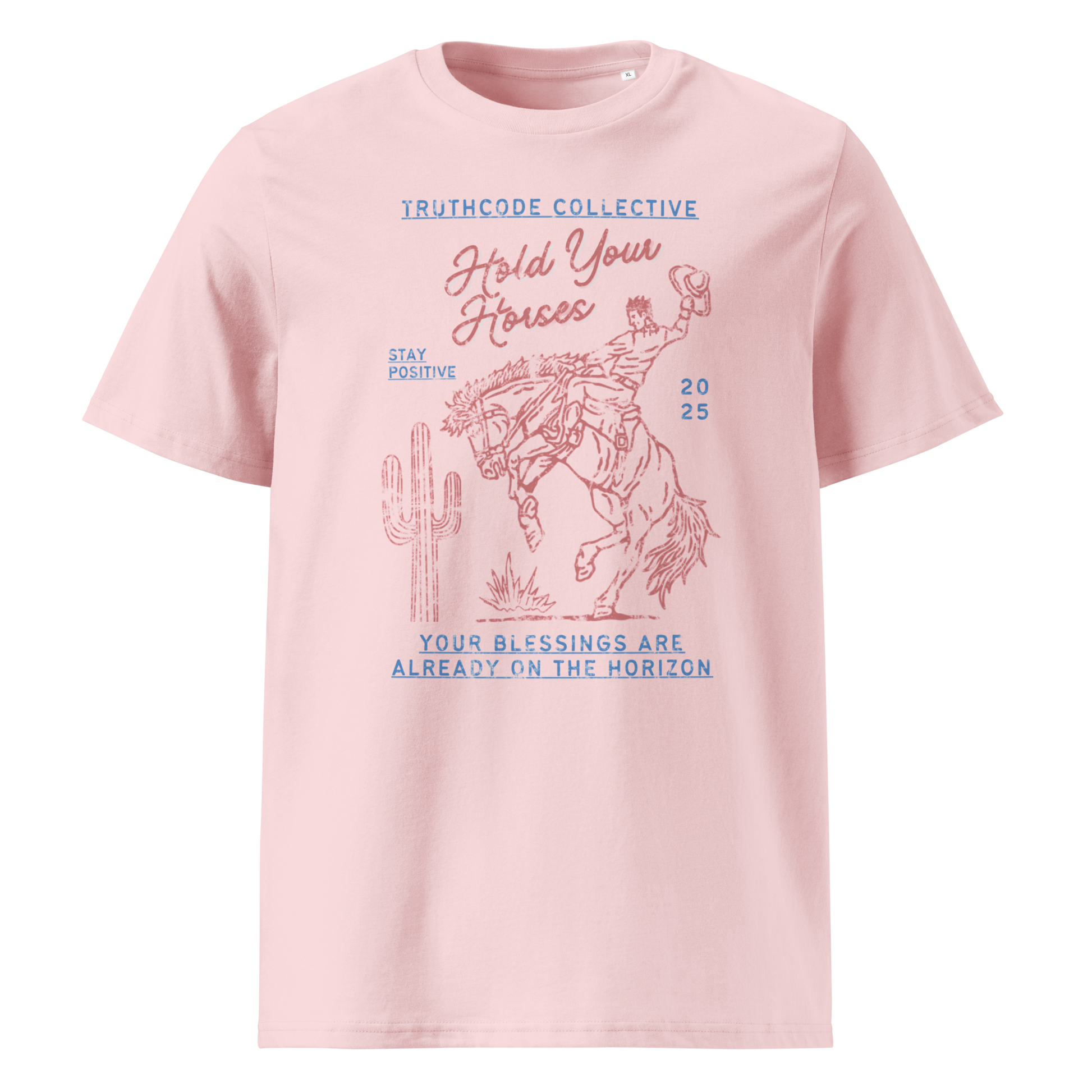 Pink organic t- shirt with a western style graphic of a cowboy on a bucking bronco, with the text 'Hold your horses, your blessings are already on the horizon'